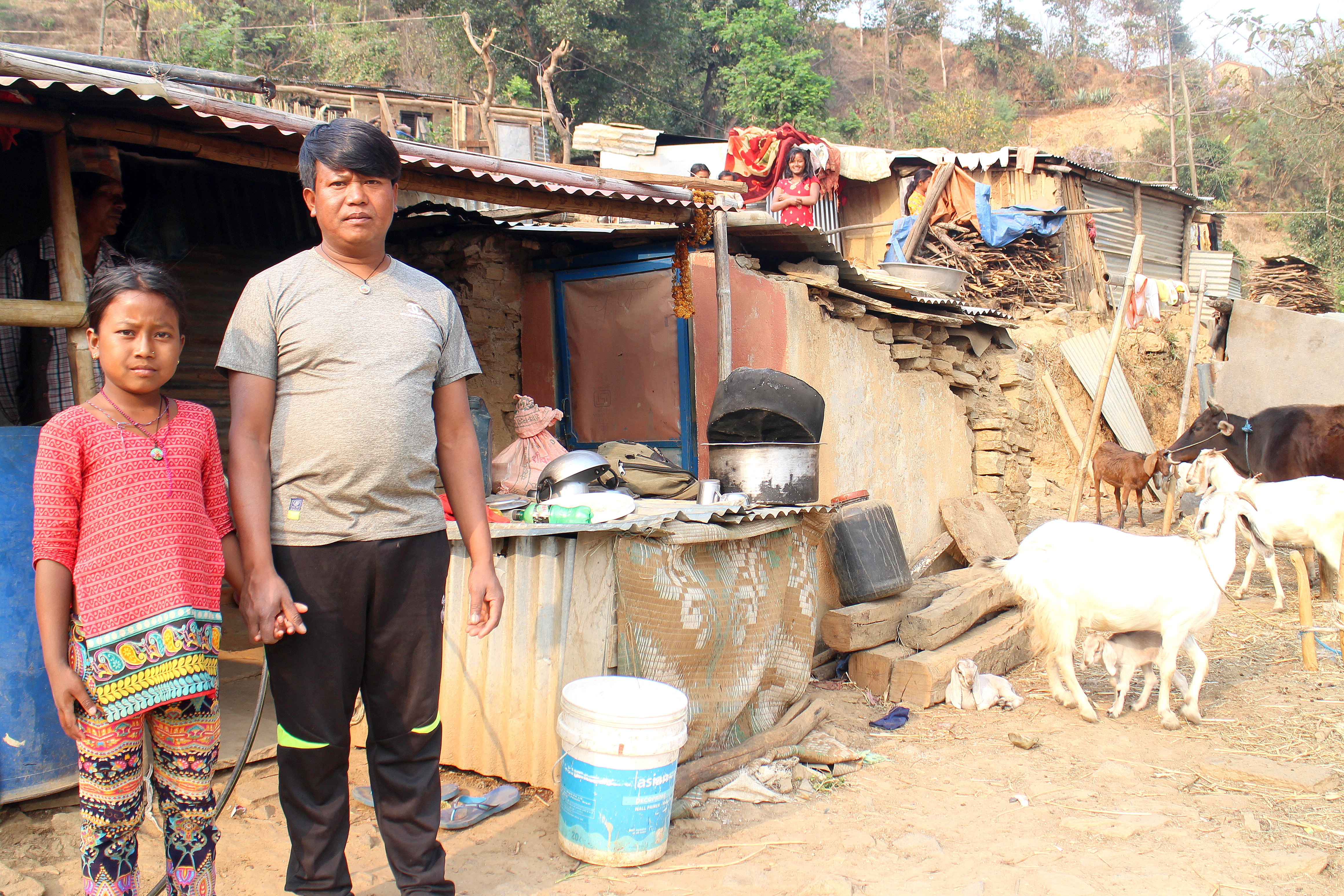 Surya Bahadur Majhi och hans dotter Sajina Majhi framför deras nuvarande hem. Med stöd från Build Up Nepal hoppas de kunna bygga ett jordbävningsäkert hem. Foto: Josefine Nilsson