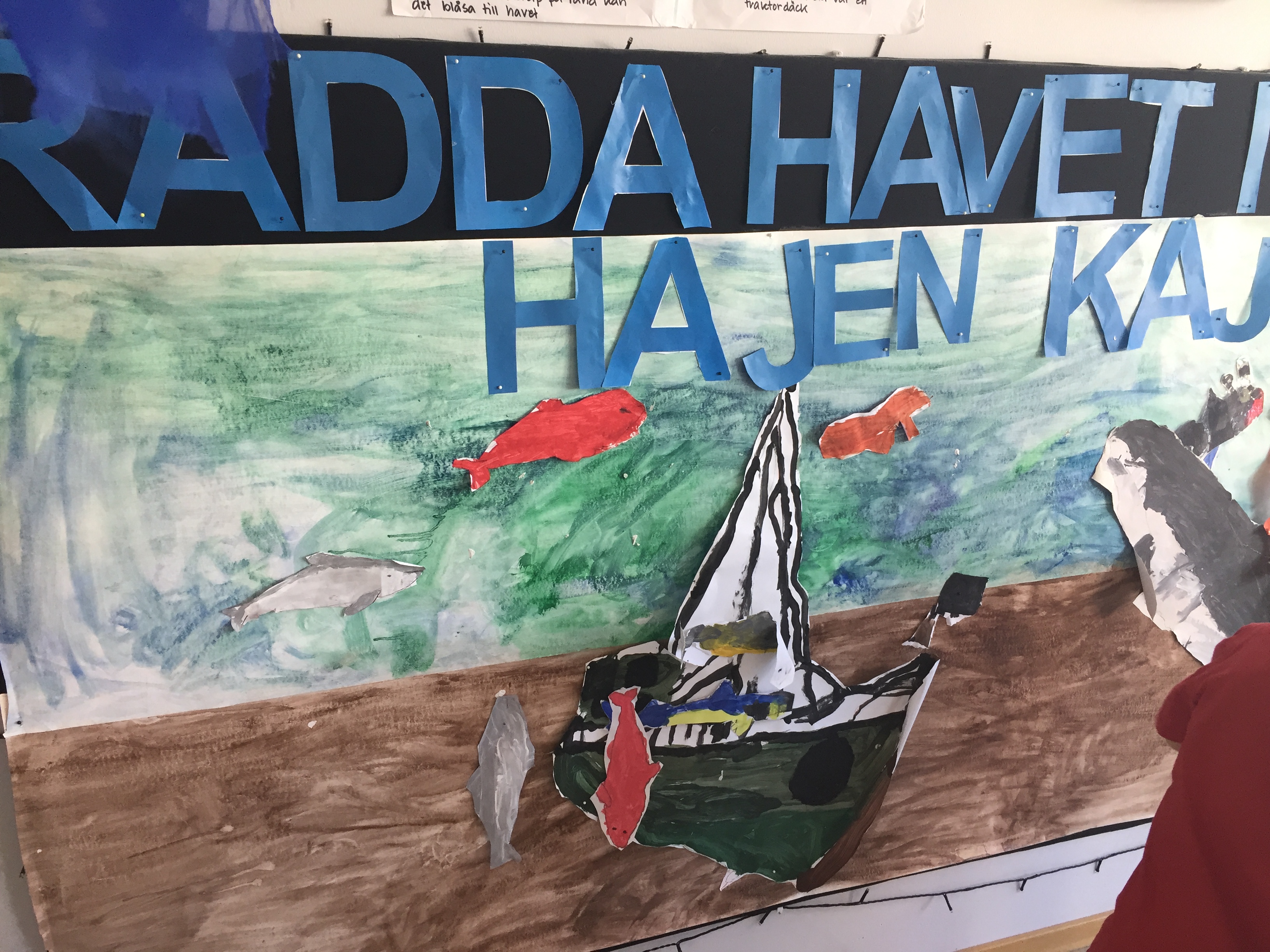 "Rädda havet med Hajen Kaj" syftar på en saga som barnen har läst tillsammans.
